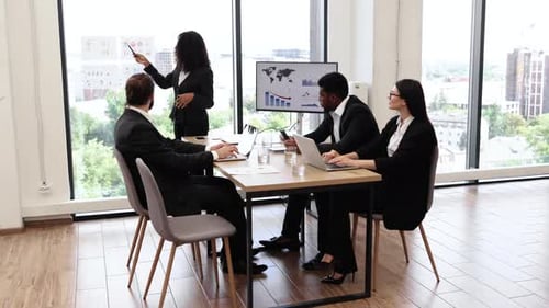 Business Woman Presenting Report to Colleagues in Modern Office