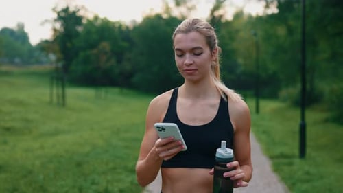 Young Woman Uses Smartphone After Workout