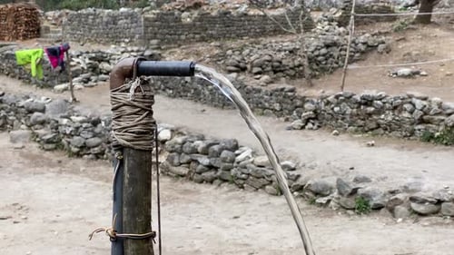A water pipe spewing water in the Himalayan Mountains of Nepal.