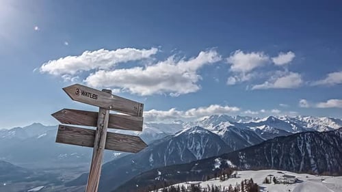 Wooden Sign Post Arrow Pointing To Watles Ski Resort In South Tyrol, Italy In Winter. time lapse