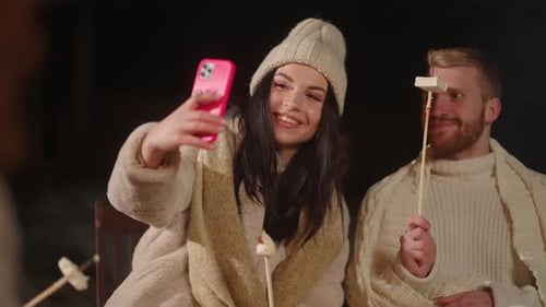 Young Adults Take Selfie Toasting Marshmallows by Fire
