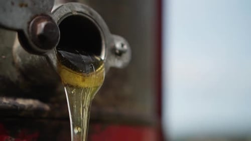 Close-up of honey flows out of a honeycomb extractor. Slow motion 120p