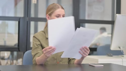 Young Businesswoman Reading Documents at Work