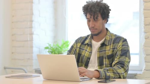 African Man Leaving Office after Closing Laptop