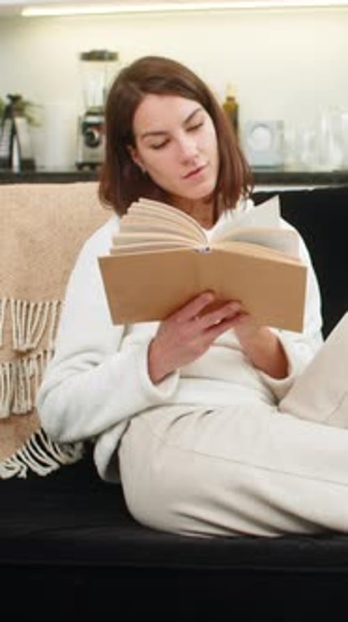 Woman reading a book on a cozy couch