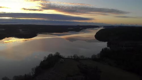 Aerial view at evening of an orange sunset reflecting on a lake, peaceful background