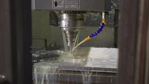 CNC Drilling with Coolant Spray in Metal Workshop