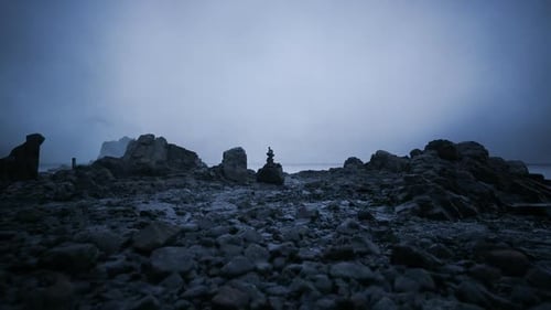 Dark Coastal Landscape with Balancing Stones at Twilight Hour