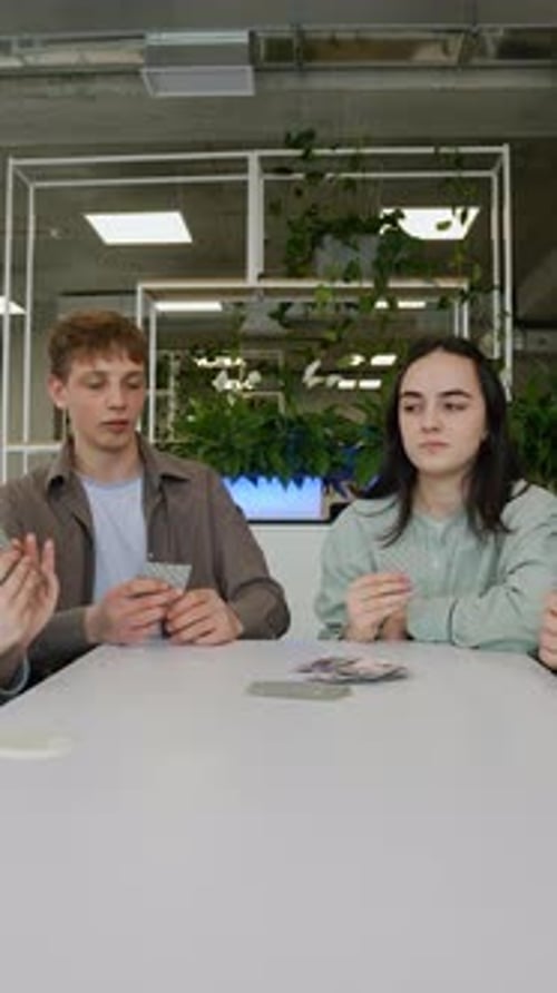Teenagers Playing Cards in Modern Office Breakroom