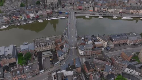 Des voitures circulent sur le pont Charles De Gaulle à Dinant, en Belgique, des bateaux accostent le long des rives de la Meuse