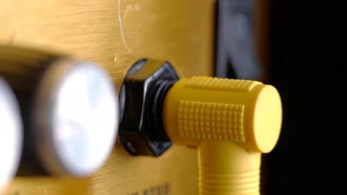 Yellow Cable Being Plugged Into a Gold Amplifier