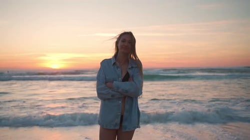 Happy Woman in Denim Shirt Walking Near Sea at Beach During Sunser