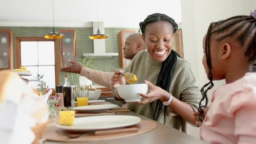 Smiling Woman Serves Sweet Potatoes at Dinner Table