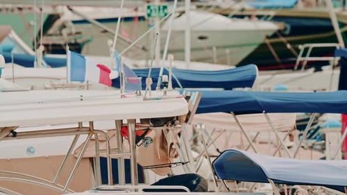 Un port de plaisance animé rempli de voiliers, de auvents et de drapeaux français, créant un motif superposé de bleu