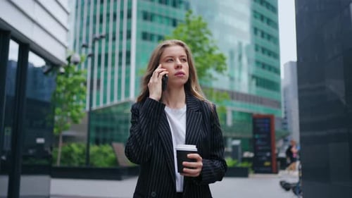 Confident Businesswoman Talking By Cellphone and Walking on City Street Portrait in Motion