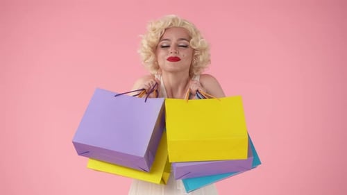 Young Happy Woman Holding Colorful Shopping Bags Woman Looking Like in Studio on Pink Background
