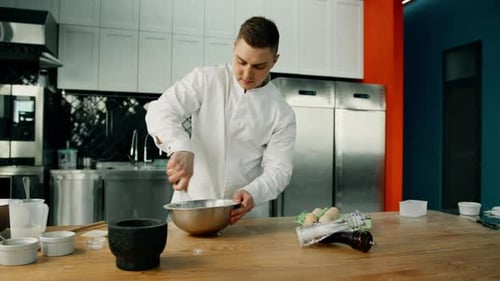 Chef Whisking Ingredients in Professional Kitchen
