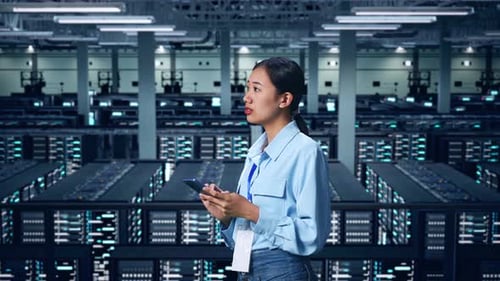 Side View Of Asian Business Woman Using Mobile Phone An Looking Around In Data Center