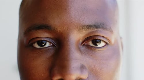 Smiling African American man looking directly at camera, close-up of eyes and face
