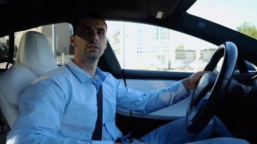 Profile of Handsome Businessman Driving a Modern Electric Car at Urban Road Male Successful