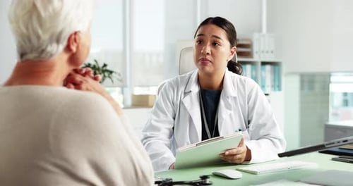 Doctor Discussing Health with Senior Patient in Clinic