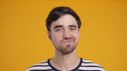 Young Man Smiling in Front of Yellow Background