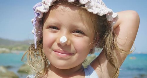 Portrait of beautiful little girl having fun on the sea, cute smiling in panama, sun protection cr