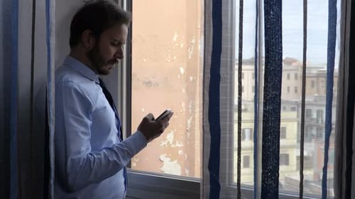 attractive business man at the window uses the phone