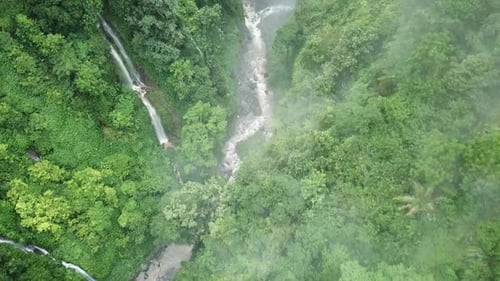 Beautiful aerial footage of the river near the the waterfall in Bali