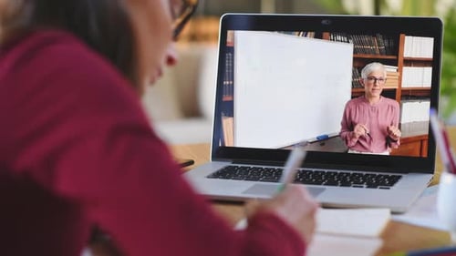 Young Adult Attending Online Lesson, Taking Notes