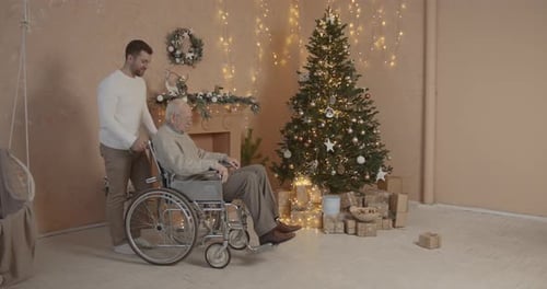 Man Pushing Senior in Wheelchair at Christmas