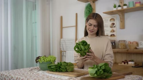 Woman Inspects Lettuce in Bright Kitchen for Salad