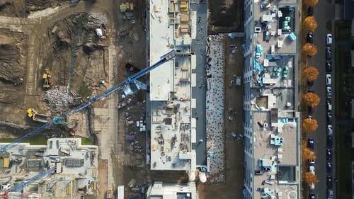 Survol aérien d'un site de développement de nouvelles constructions avec des grues à haute tour qui construisent des biens immobiliers.