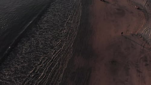 People enjoying time on the beach of Costa Rica by the waves - aerial