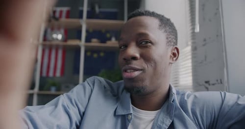 Smiling Young Man Talking To Camera