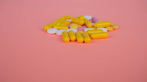 Pills and Capsules on Pink Background, Still Shot