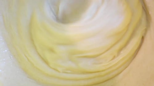 Kneading the dough using a blender, extreme close-up. The process of making a delicious cake.