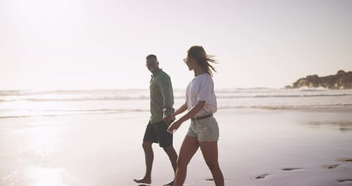4k video footage of an attractive young couple spending the day together at the beach