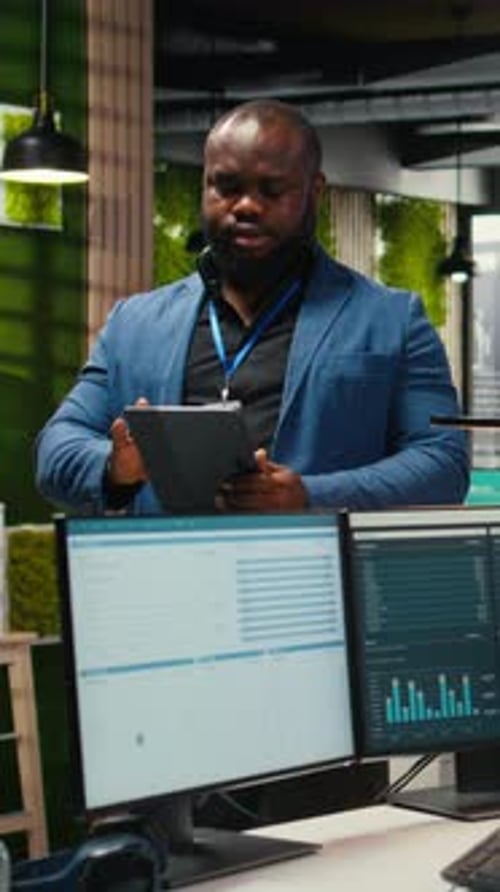 Vertical Video African American Office Worker Uses Tablet to Examine Business Resources