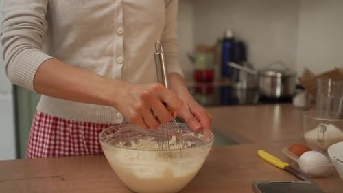 Woman Mixing Cake Batter with Whisk in Kitchen