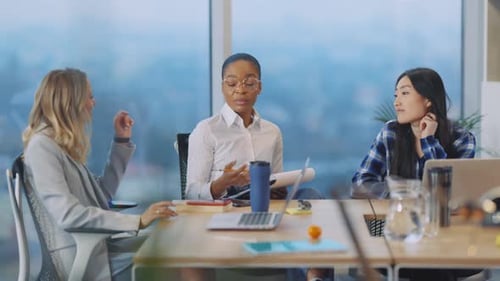 Three women work together at a conference table