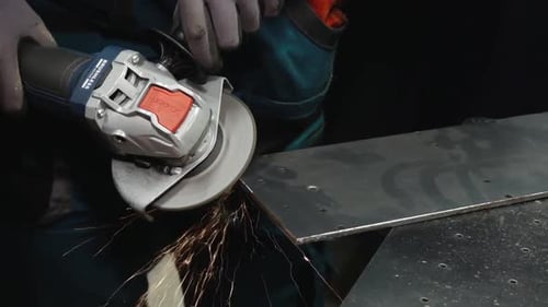 Close-up of a grinding wheel cutting or shaping a metal surface, producing vibrant sparks. A powerfu