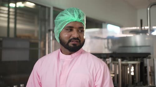 Employee is working at beverage factory.