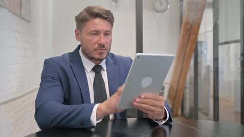 Mature Adult Businessman Working on Digital Tablet