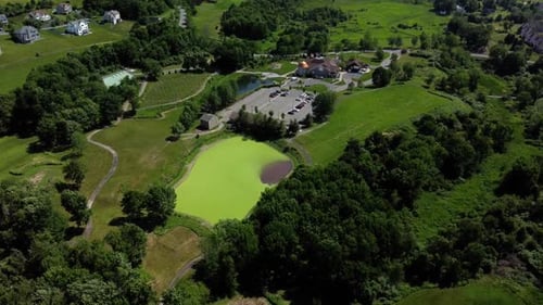 Aerial view of a banquet house for celebrations and weddings, surrounded by green land and trees. Fr