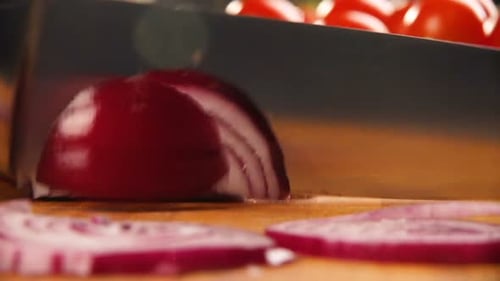 Cutting a red onion on a wooden cutting board