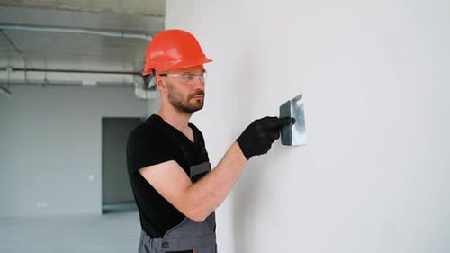 Construction Worker Smoothing Plaster on a Wall