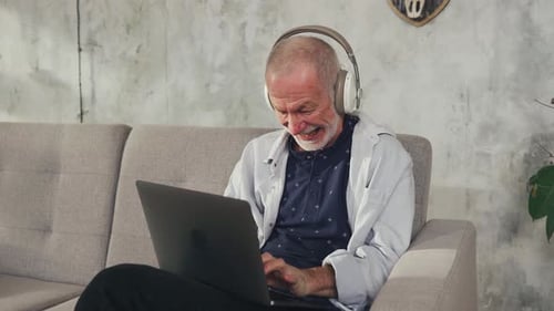 Un alegre seguidor de un anciano escribe un comentario en las redes sociales en la computadora portátil