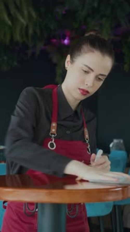 Waitress Disinfecting Tables before Cafe Opening
