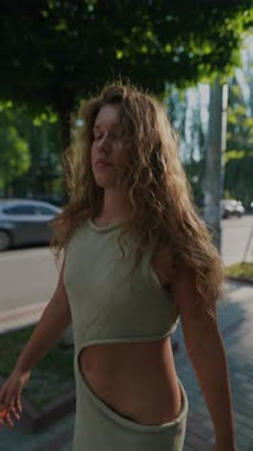 Embracing the Active Spirit of Summer a Girl with Curly Hair is Seen on the City Streets